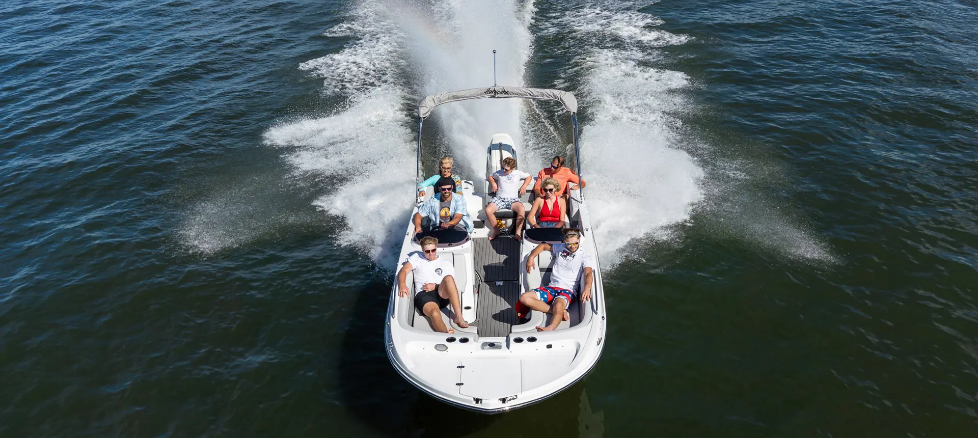 fully loaded hurricane sundeck sport ob deck boat cruising on a lake