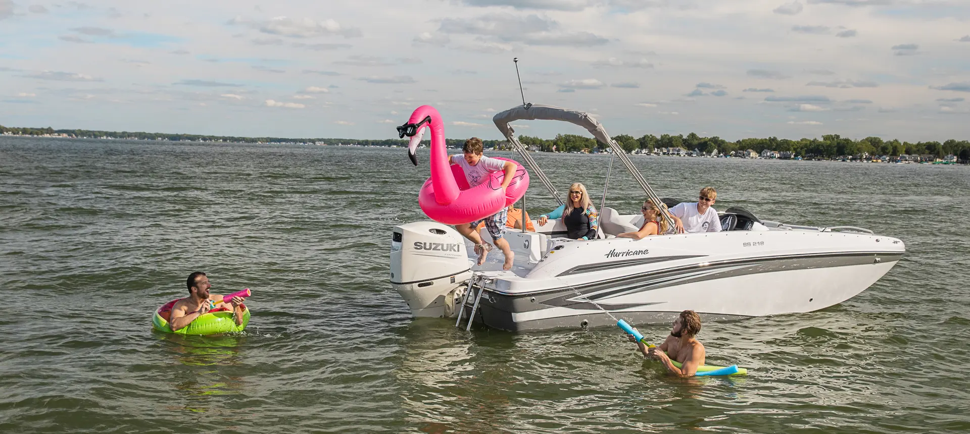 boy jumping into the water off the stern of a hurricane sundeck sport ob deck boat
