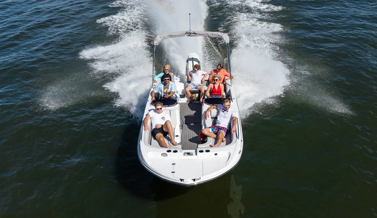 fully loaded hurricane sundeck sport ob deck boat cruising on a lake
