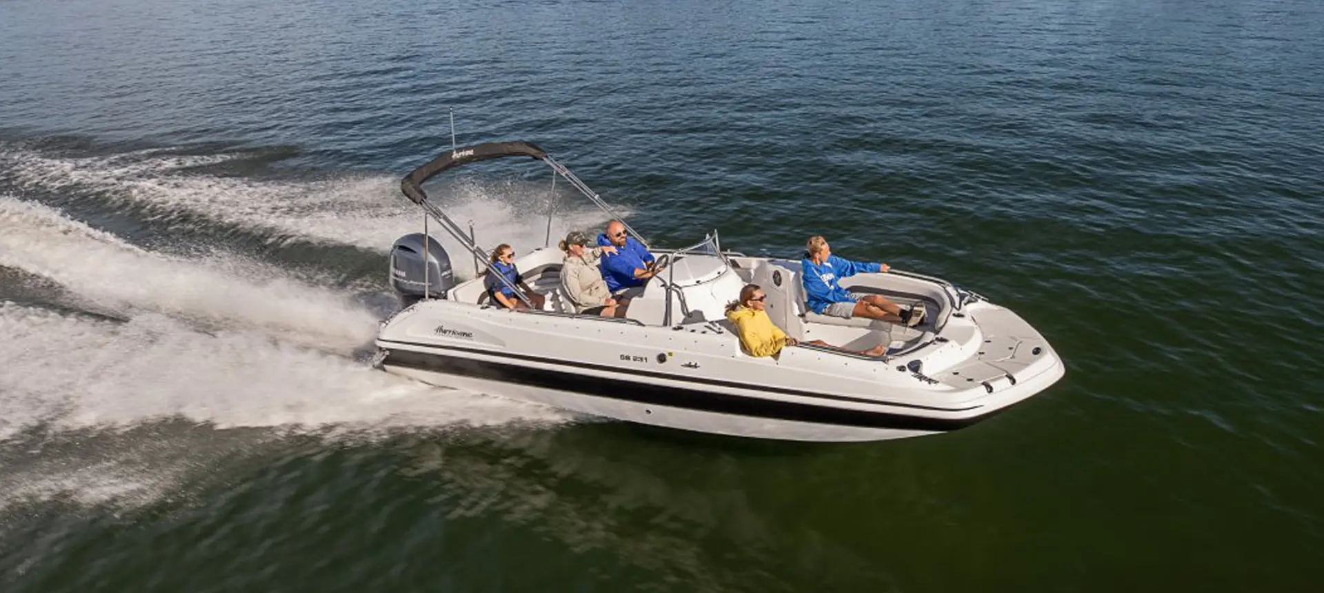 hurricane center console deck boat speeding across a lake