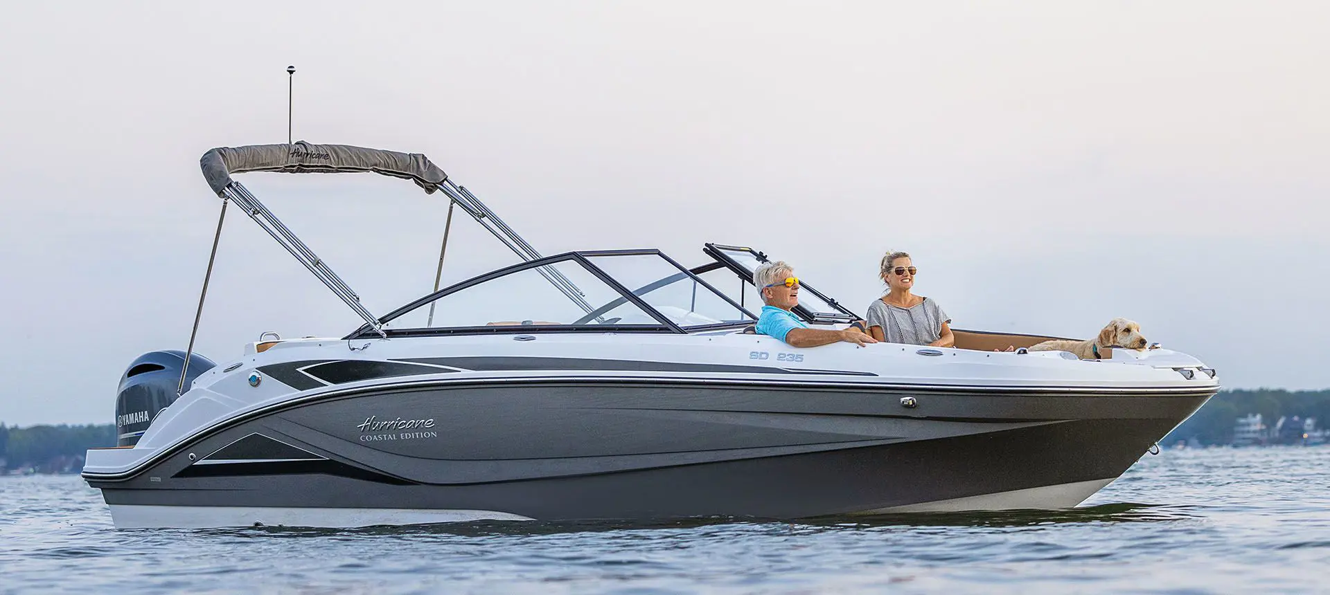 couple and their dogs relaxing on a hurricane sundeck 235 OB deck boat
