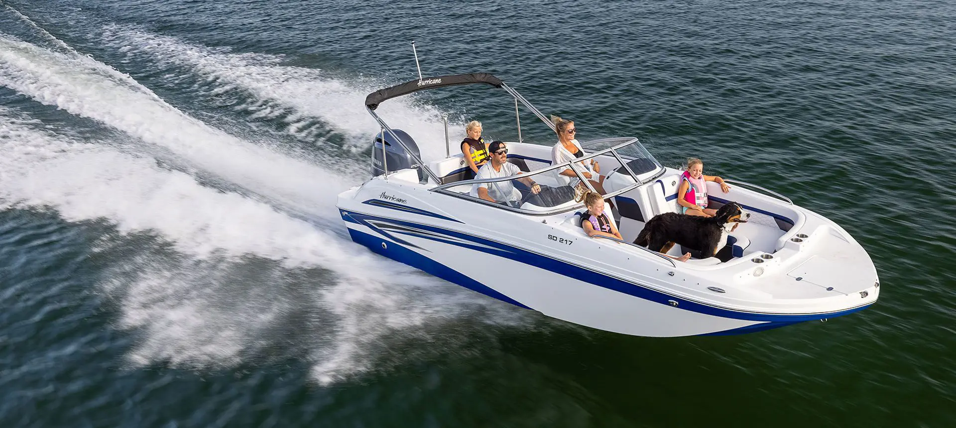 family in a hurricane sundeck 217 OB deck boat speeding across a lake