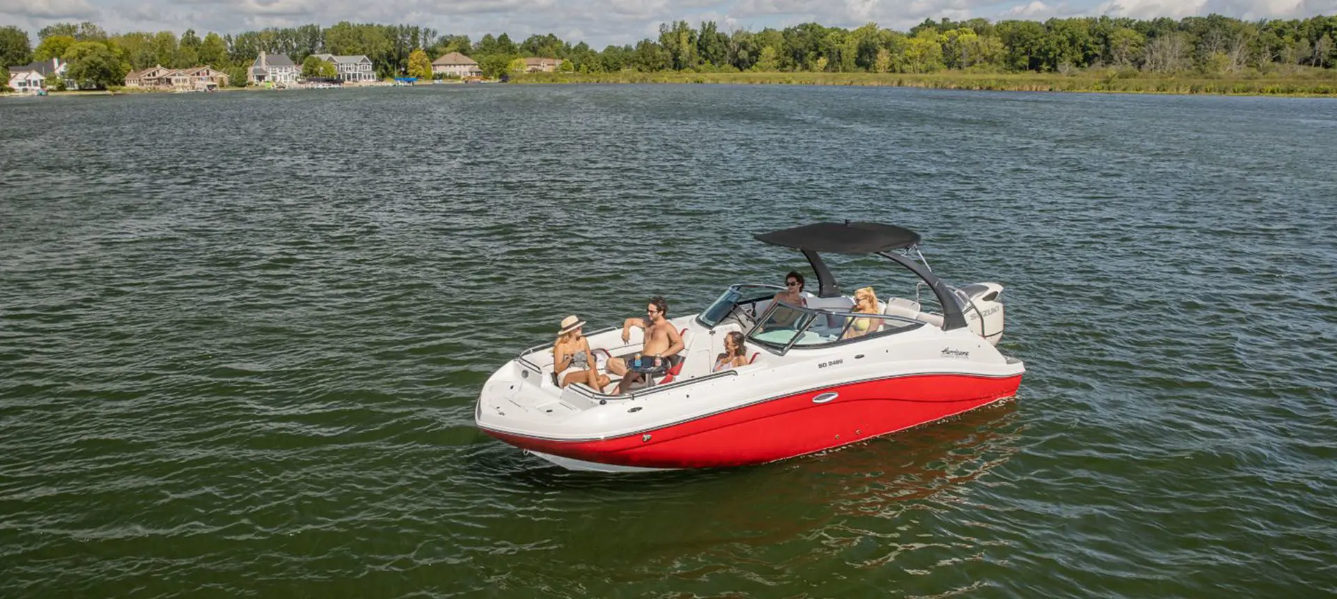 family relaxing on a floating hurricane sundeck 235 OB deck boat