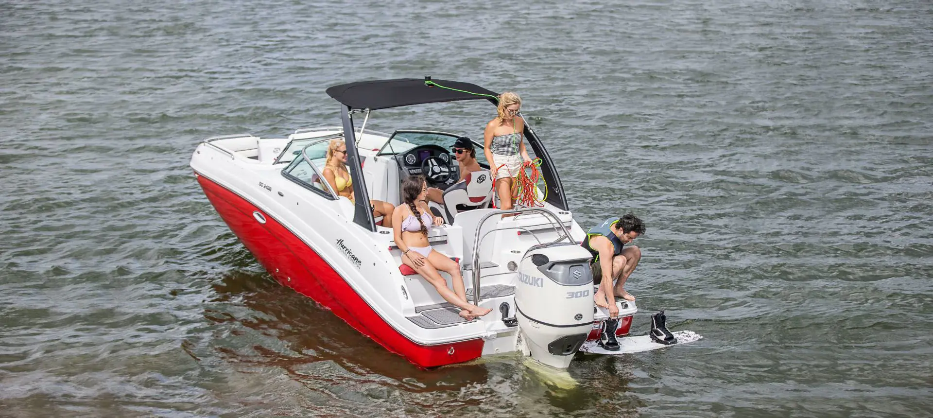 family floating and preparing to wake board with their hurricane sundeck OB deck boat