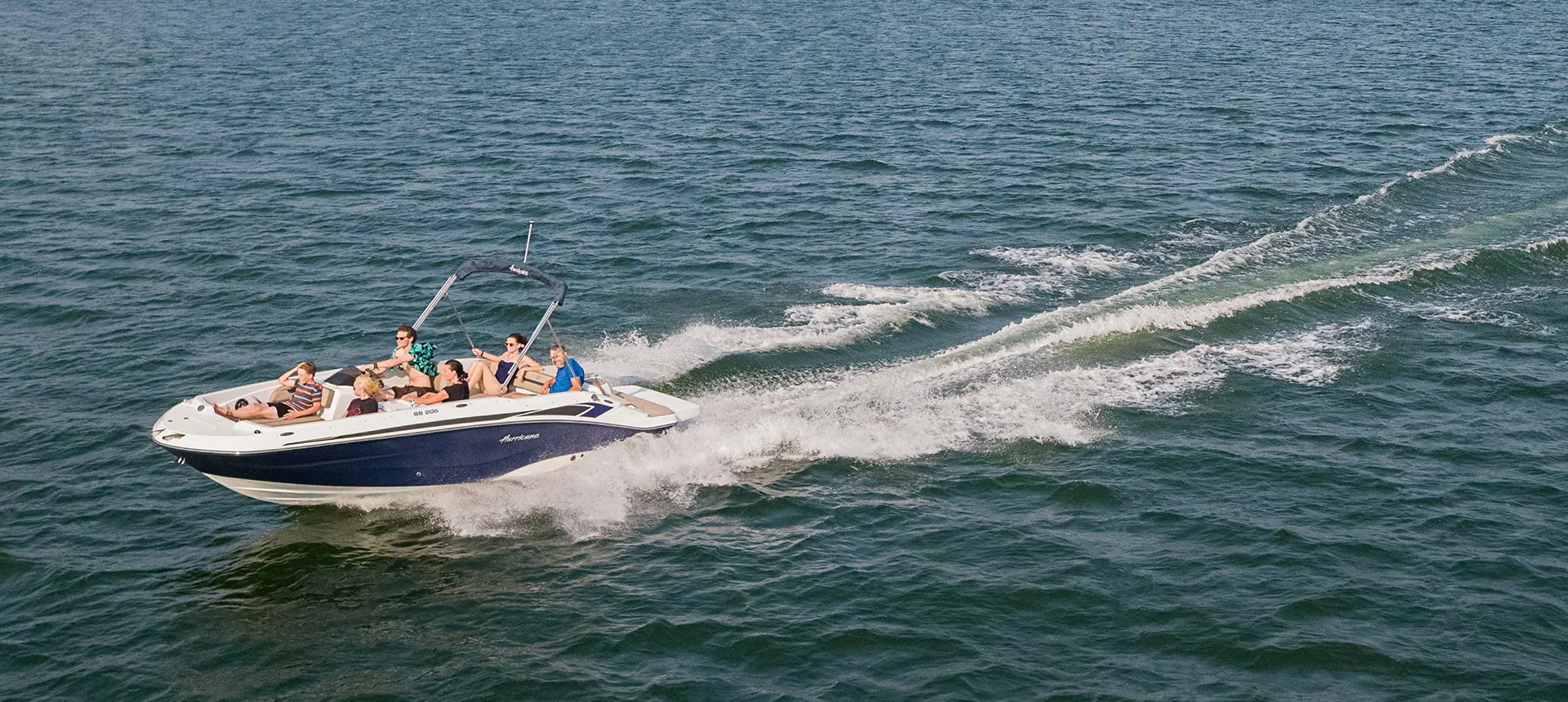 hurricane sundeck sport i/o deck boat speeding across a lake