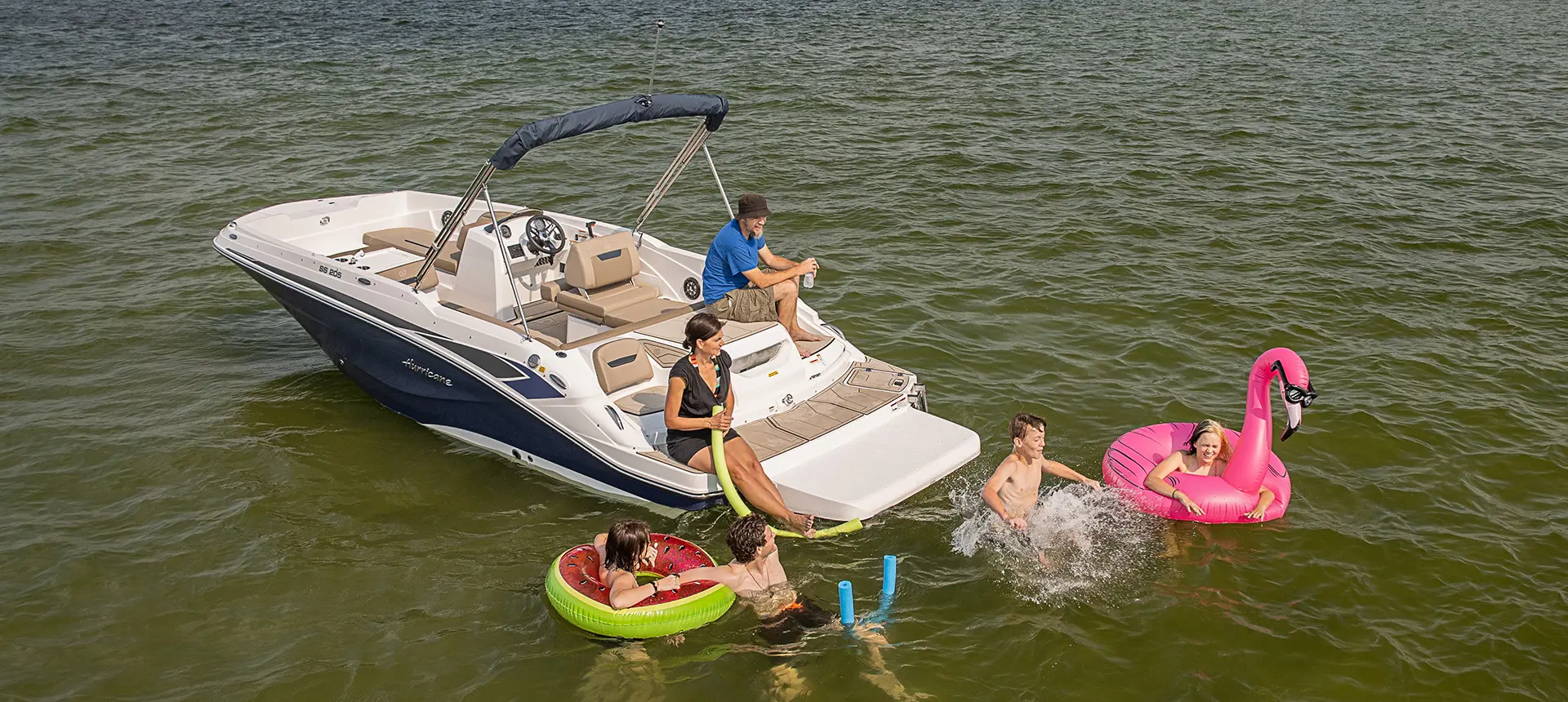 family swimming near their hurricane sundeck sport i/o deck boat