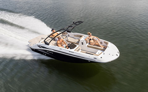 a hurricane deck boat cruising across a lake
