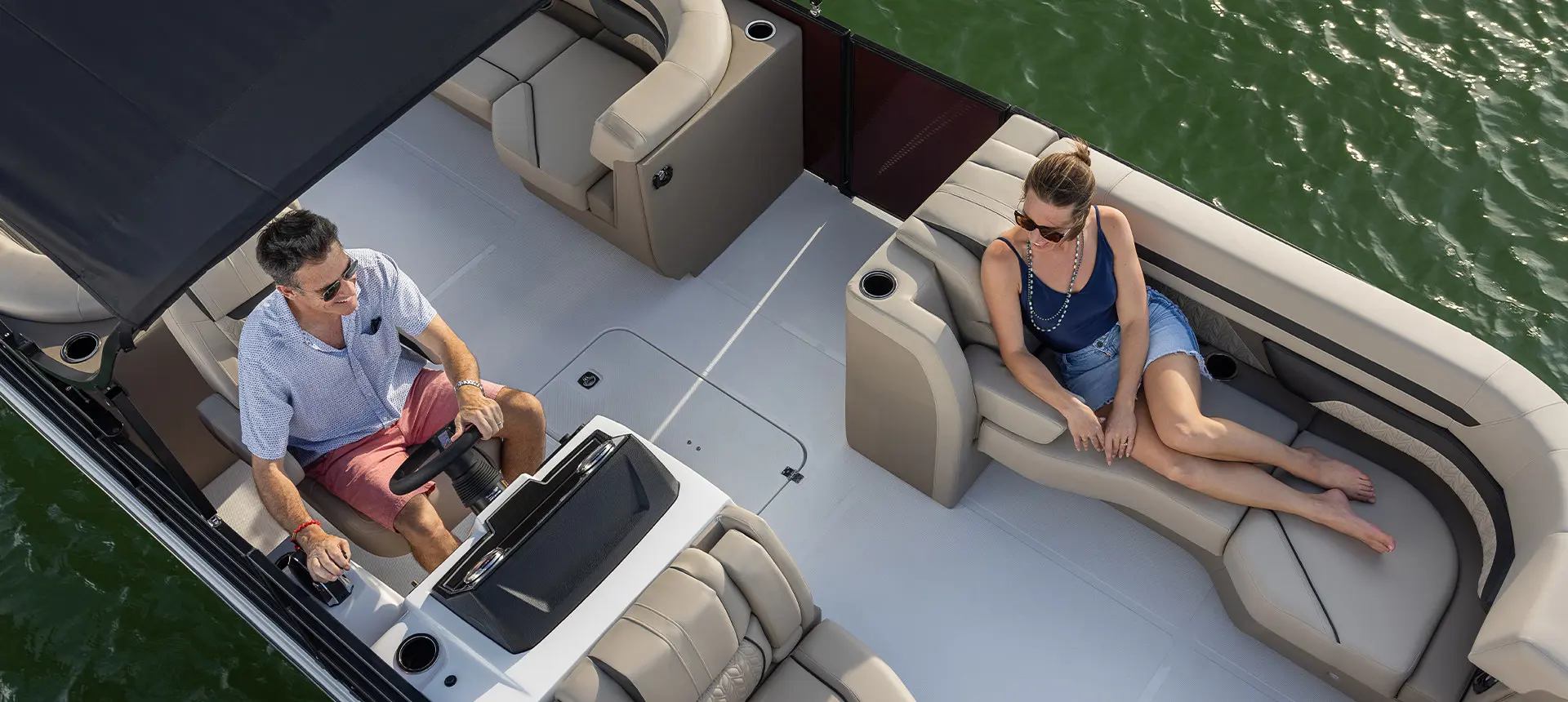 overhead view of a man at the helm and his wife on the bow split bench seat on a hurricane fundeck boat