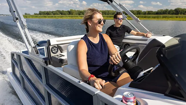 woman at the helm of a hurricane fundeck boat