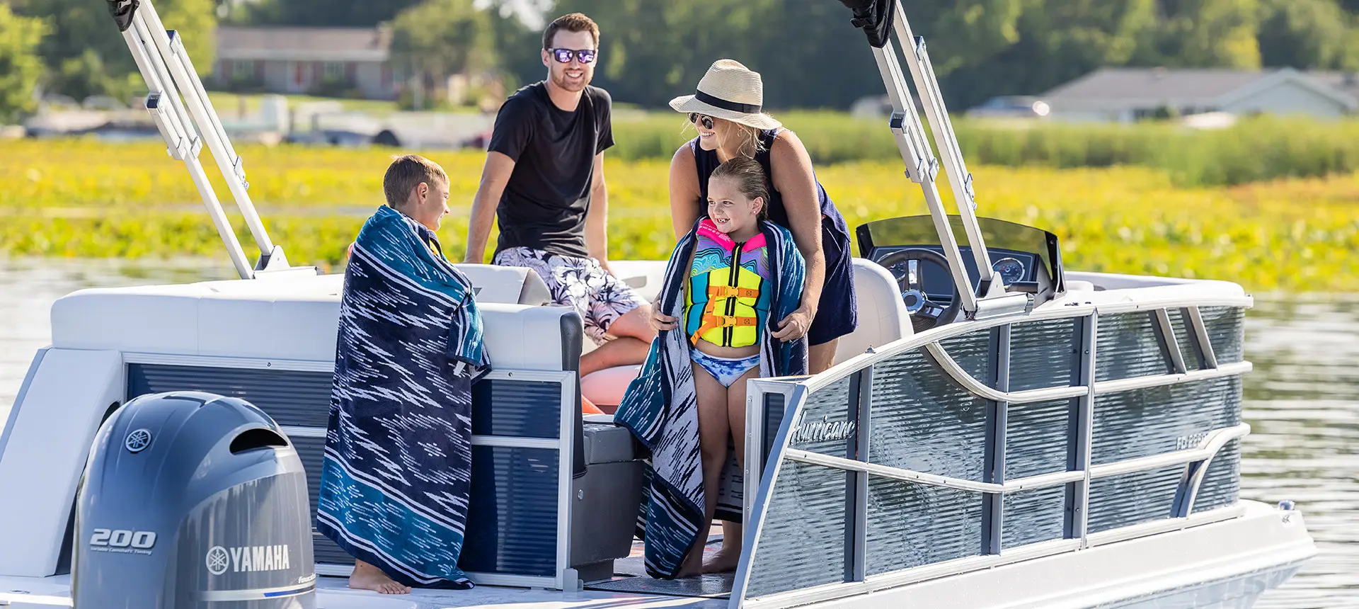 family smiling on the stern of a hurricane fundeck boat