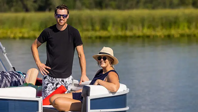 husband and wife on the bow of a hurricane fundeck boat