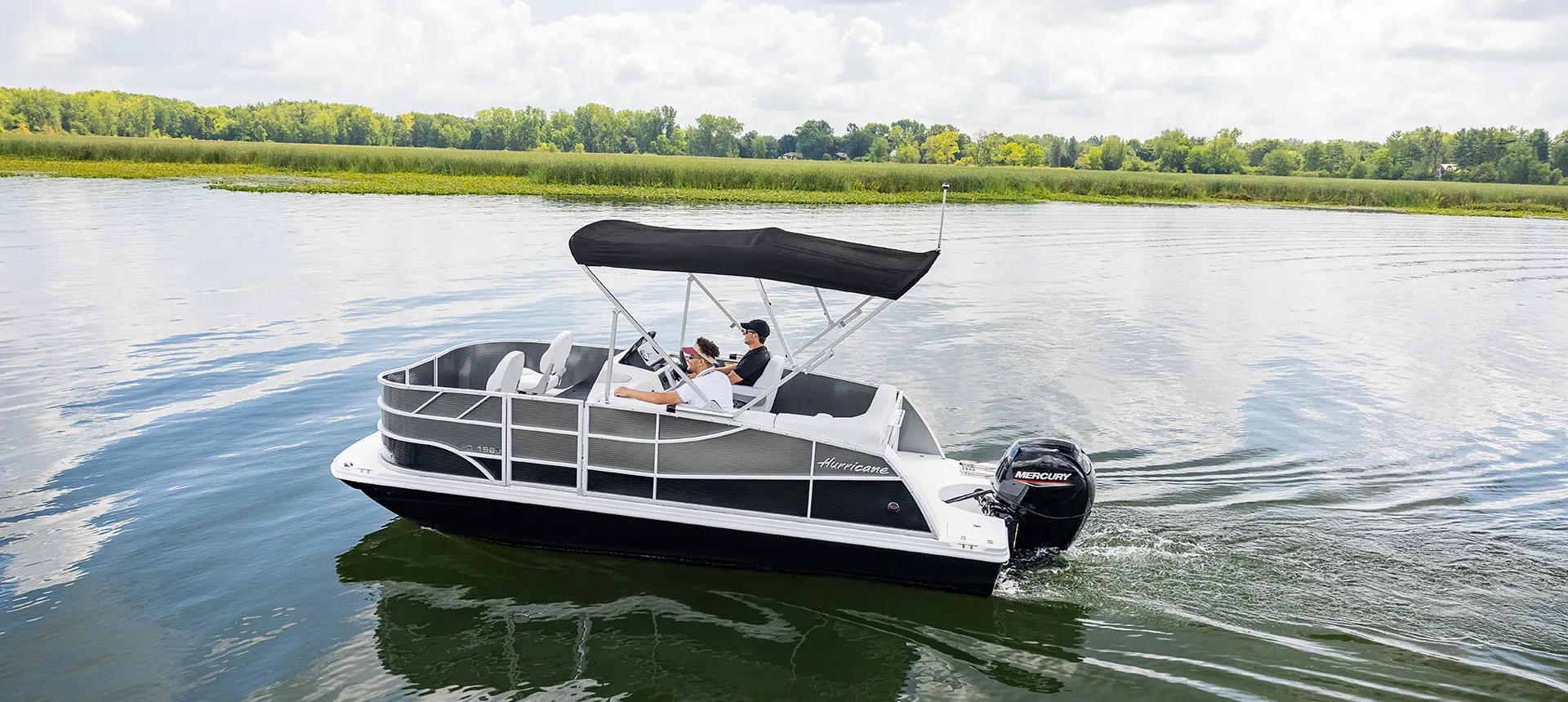 2 men driving out to a fishing spot on a hurricane fundeck boat