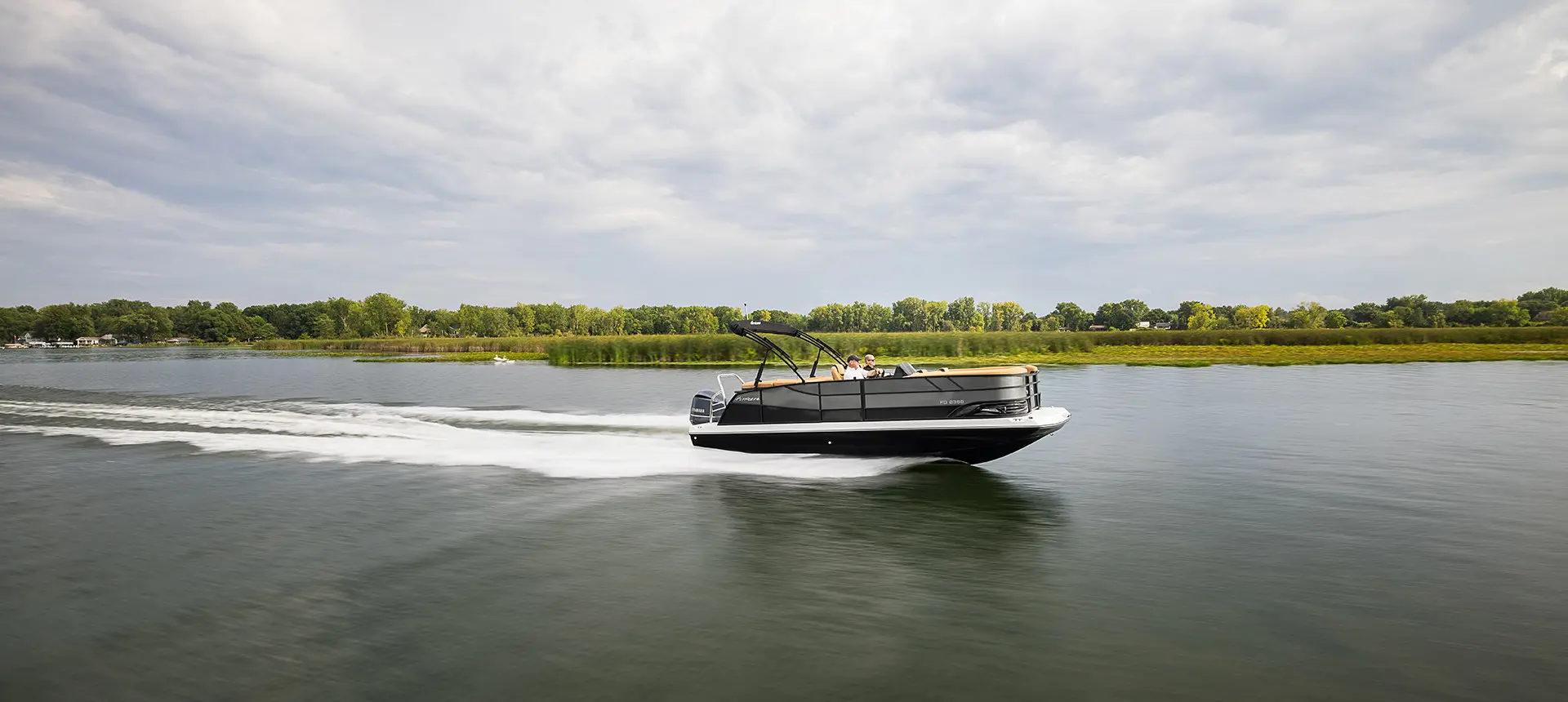 side profile of a hurricane fundeck boat cruising across a lake