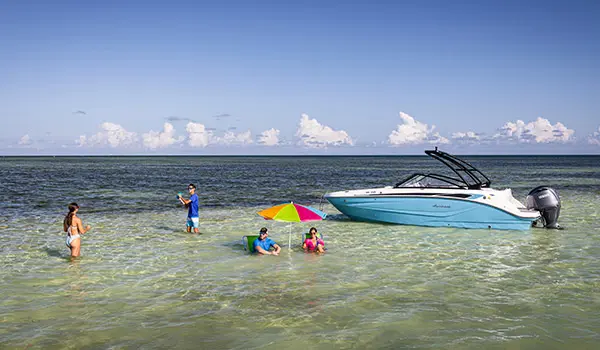 family in water surrounding parked hurricane sundeck 235 ob