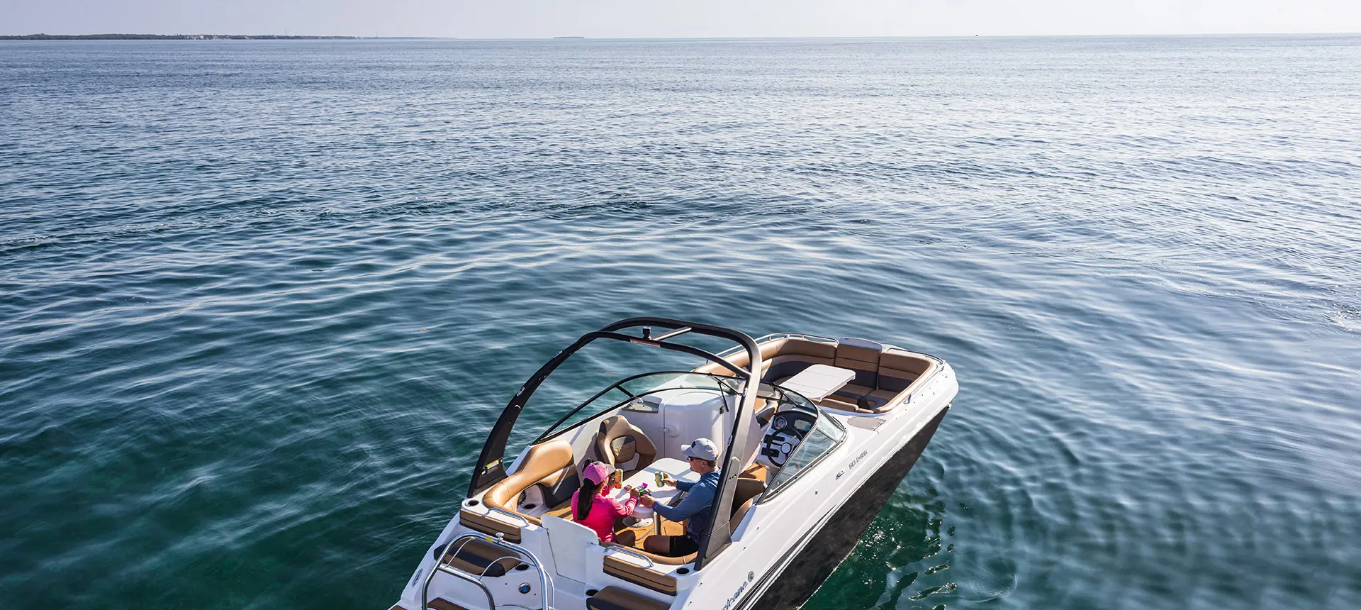 Overhead view of a couple relaxing at table seating on a Hurricane SunDeck 2486 OB.