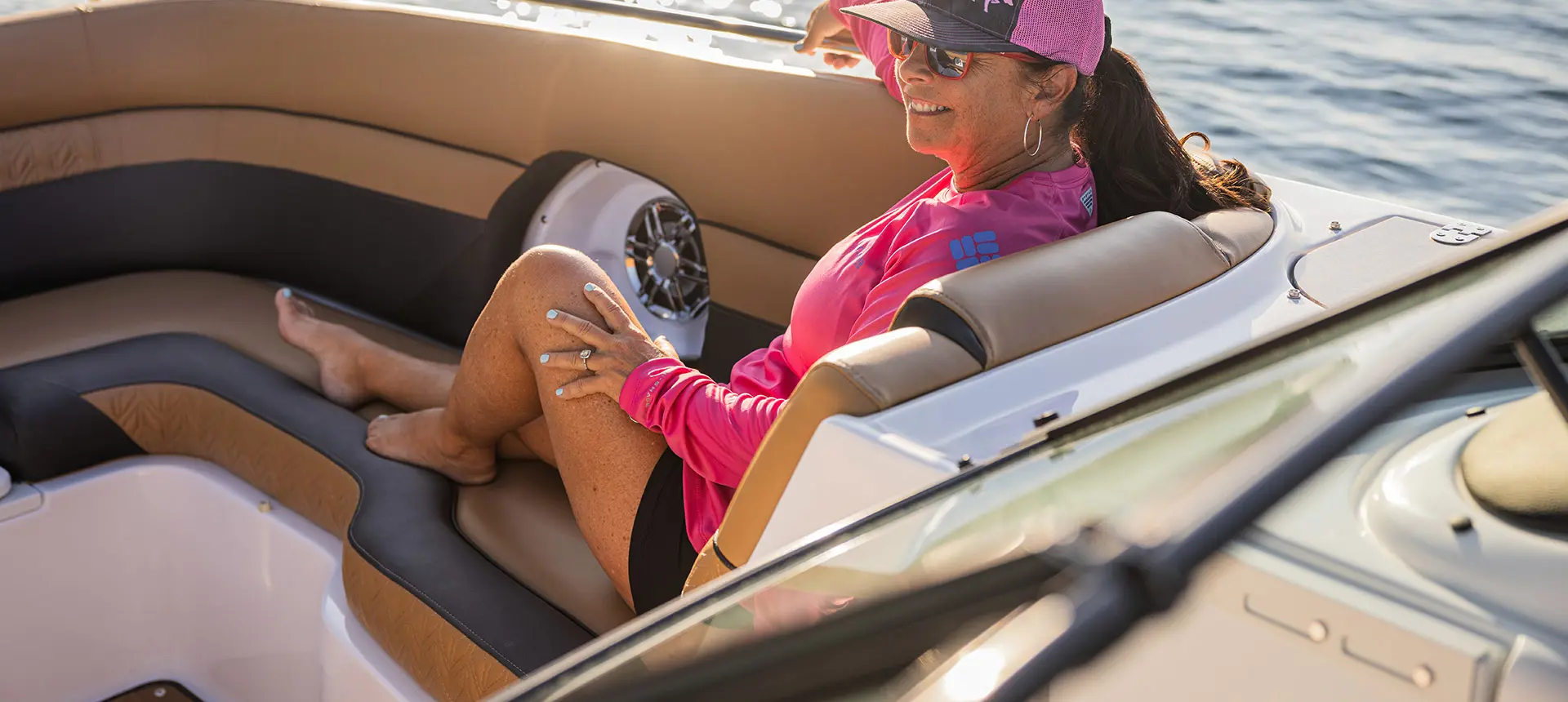 Woman smiles from front leather seating on a Hurricane SunDeck 2486 OB.