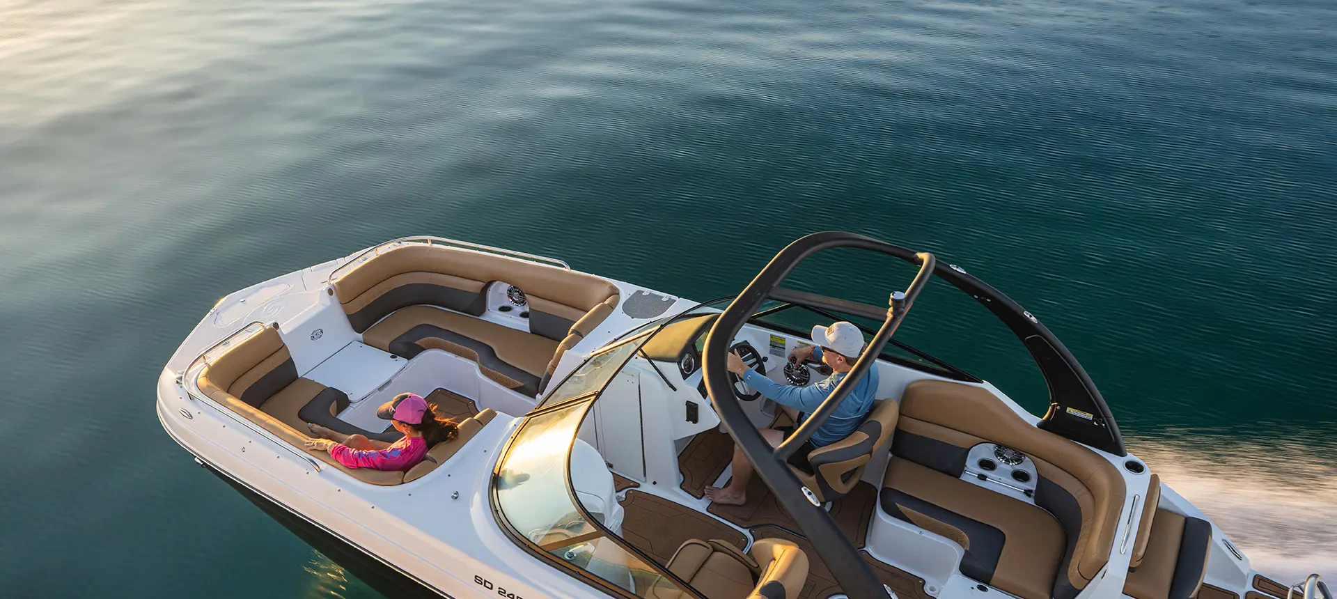 Overhead view of a couple cruising across lake on a Hurricane SunDeck 2486 OB.