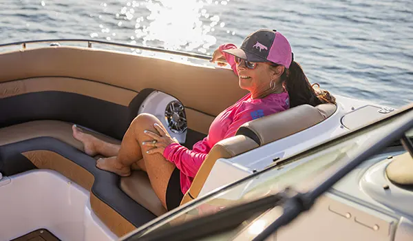 Woman smiles from front leather seating on a Hurricane SunDeck 2486 OB.