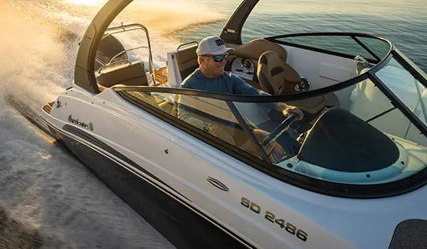 Man speeding across water on a Hurricane SunDeck 2486 OB.