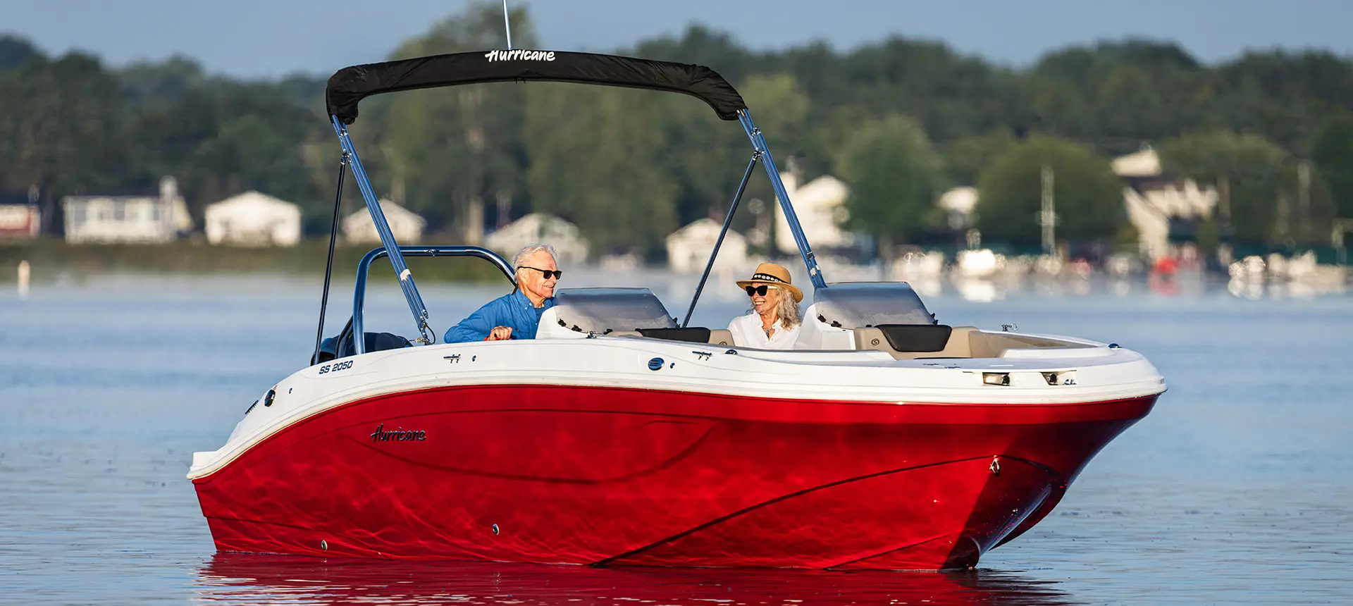 Bow focused view of a couple floating the lake on their Hurricane SunDeck Sport 2050 OB deck boat.