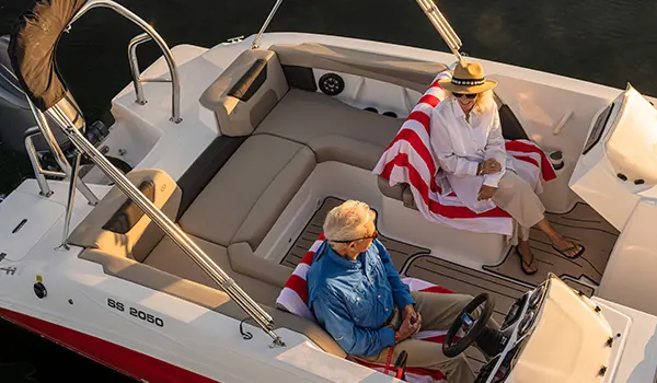 Aerial view of a couple smiling at each other on a Hurricane SunDeck Sport 2050 OB deck boat.