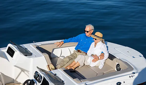 Couple relaxing on the bow of a Hurricane SunDeck Sport 2050 OB deck boat.