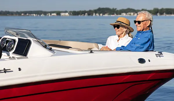 Couple relaxing on the bow seating on a Hurricane SunDeck Sport 2050 OB deck boat.