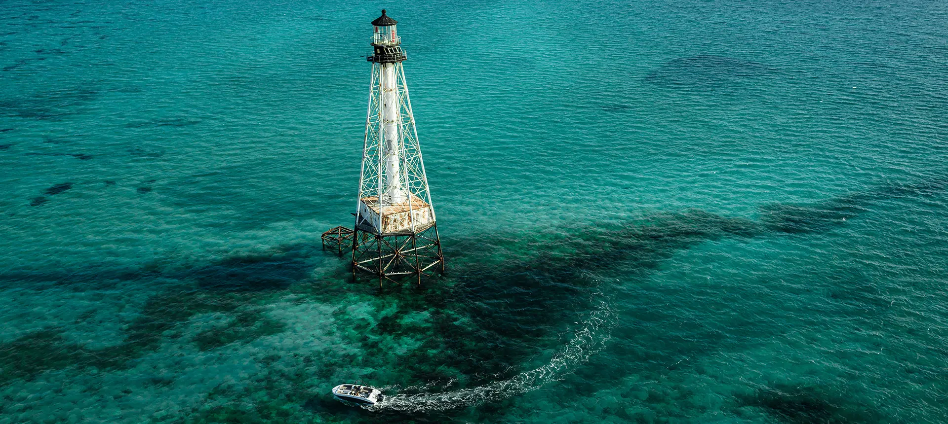 Aerial view of a Hurricane SunDeck Sport 218 OB deck boat on the ocean.