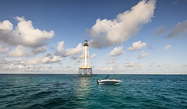 Side view of a Hurricane SunDeck Sport 218 OB deck boat floating on the ocean.