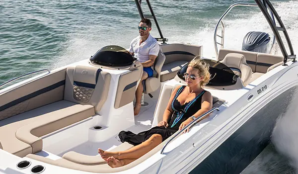 A couple cruising the ocean on a Hurricane SunDeck Sport 218 OB deck boat.