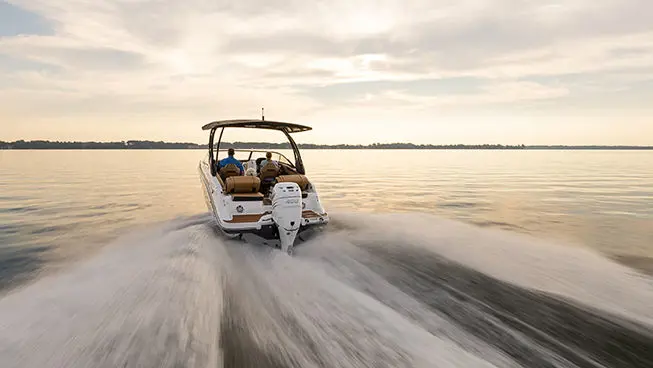 rear view of a hurricane sundeck ob boat speeding across a lake
