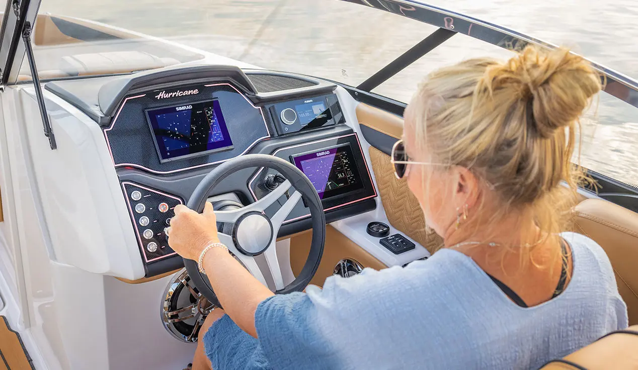 woman at the helm of a hurricane sundeck ob boat