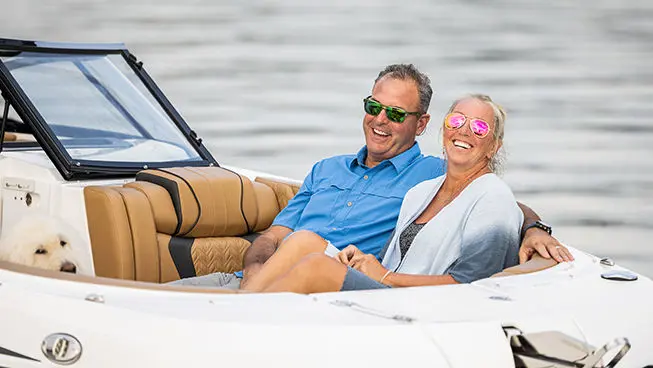 couple smiling from the bow seating on a hurricane sundeck ob boat