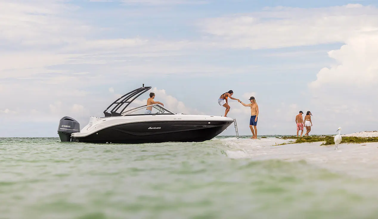 woman getting helped off the bow of a hurricane sundeck ob boat