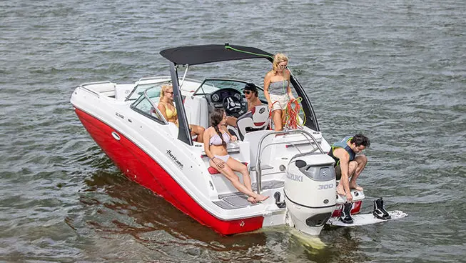 man getting ready to wake board behind a hurricane sundeck ob boat
