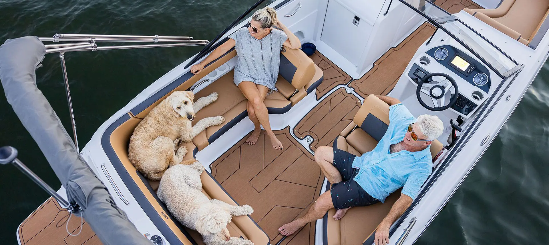 aerial view of a couple and their dogs relaxing on the stern seating on a hurricane sundeck ob boat