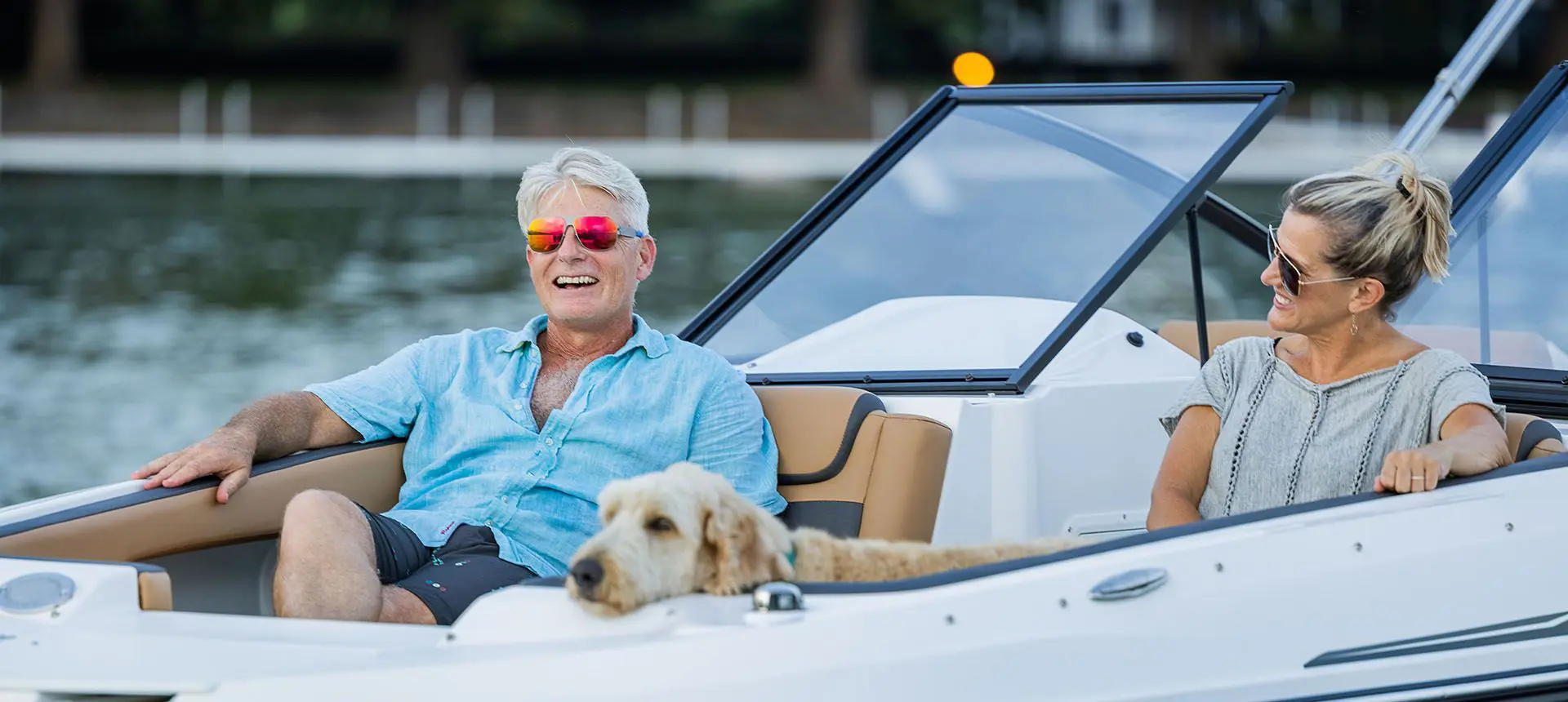 couple smiling while relaxing on the bow seats on a hurricane sundeck ob boat