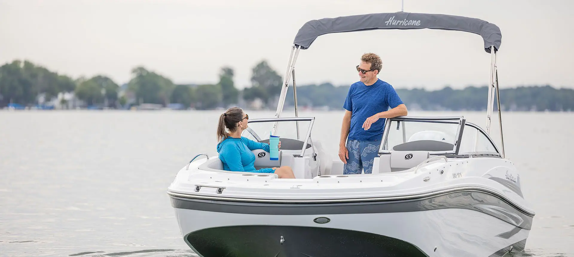 couple enjoying the lake together on their hurricane sundeck ob boat