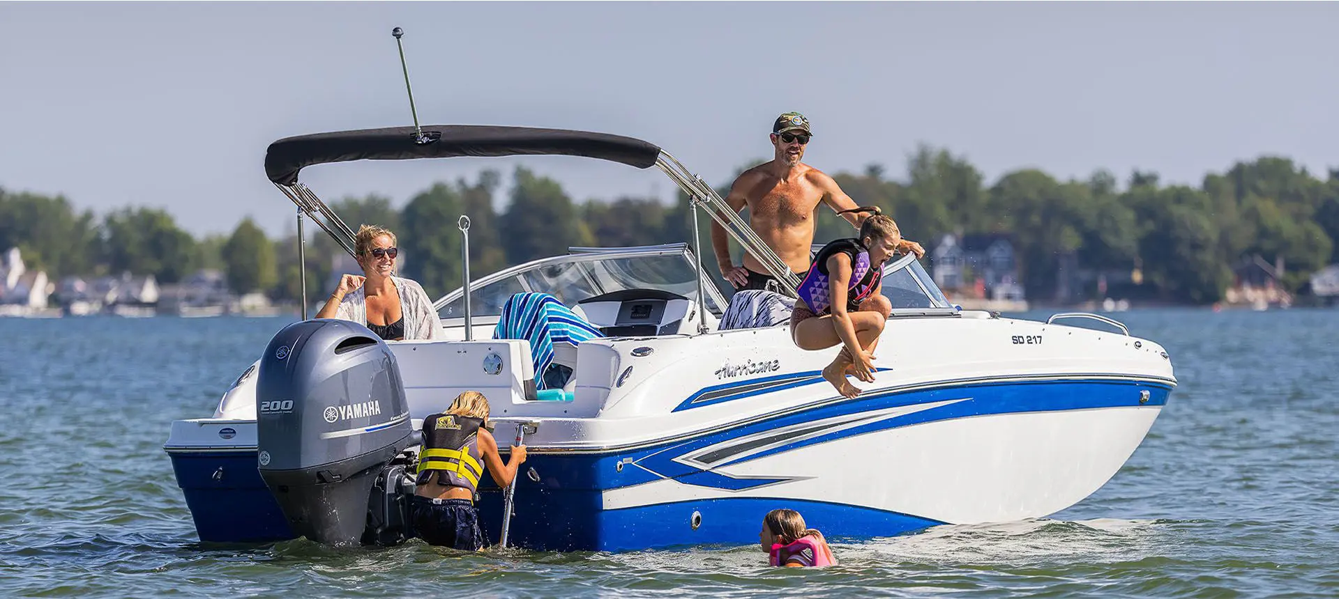 girl cannonballing off the side of a hurricane sundeck ob boat