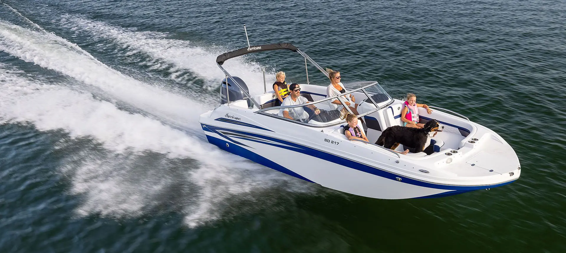 hurricane sundeck ob boat speeding across a lake