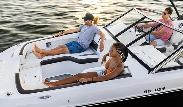 male and female lounge on front of cruising hurricane sundeck 235 ob