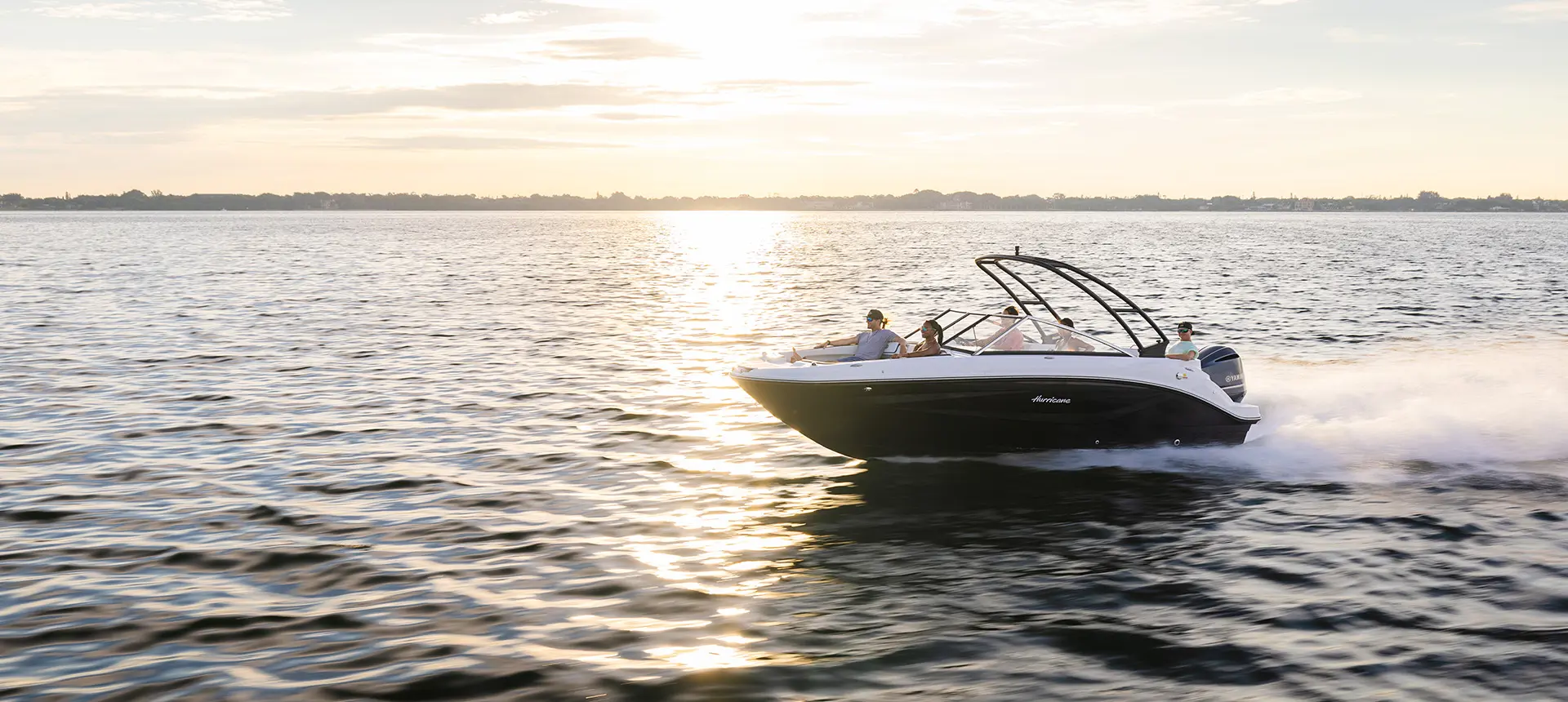 side view of hurricane sundeck 235 ob speeding on lake