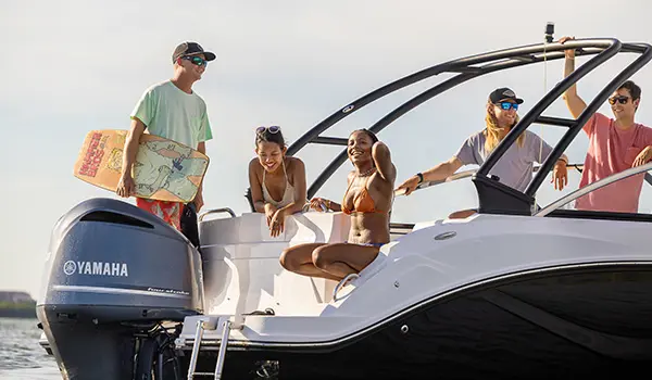 group smiles while finishing wakeboarding behind hurricane sundeck 235 ob