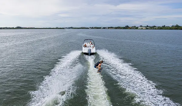 wakeboarder jumps waves behind a hurricane sundeck 235 ob