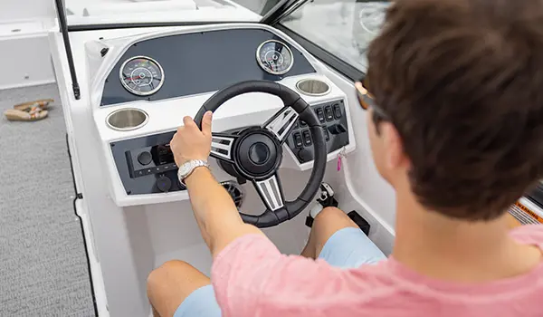 captain controls steering wheel on a hurricane sundeck 235 ob