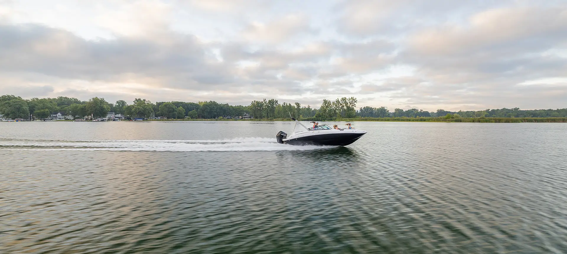 long distance side view of a hurricane sundeck 2400 ob deck boat on a lake