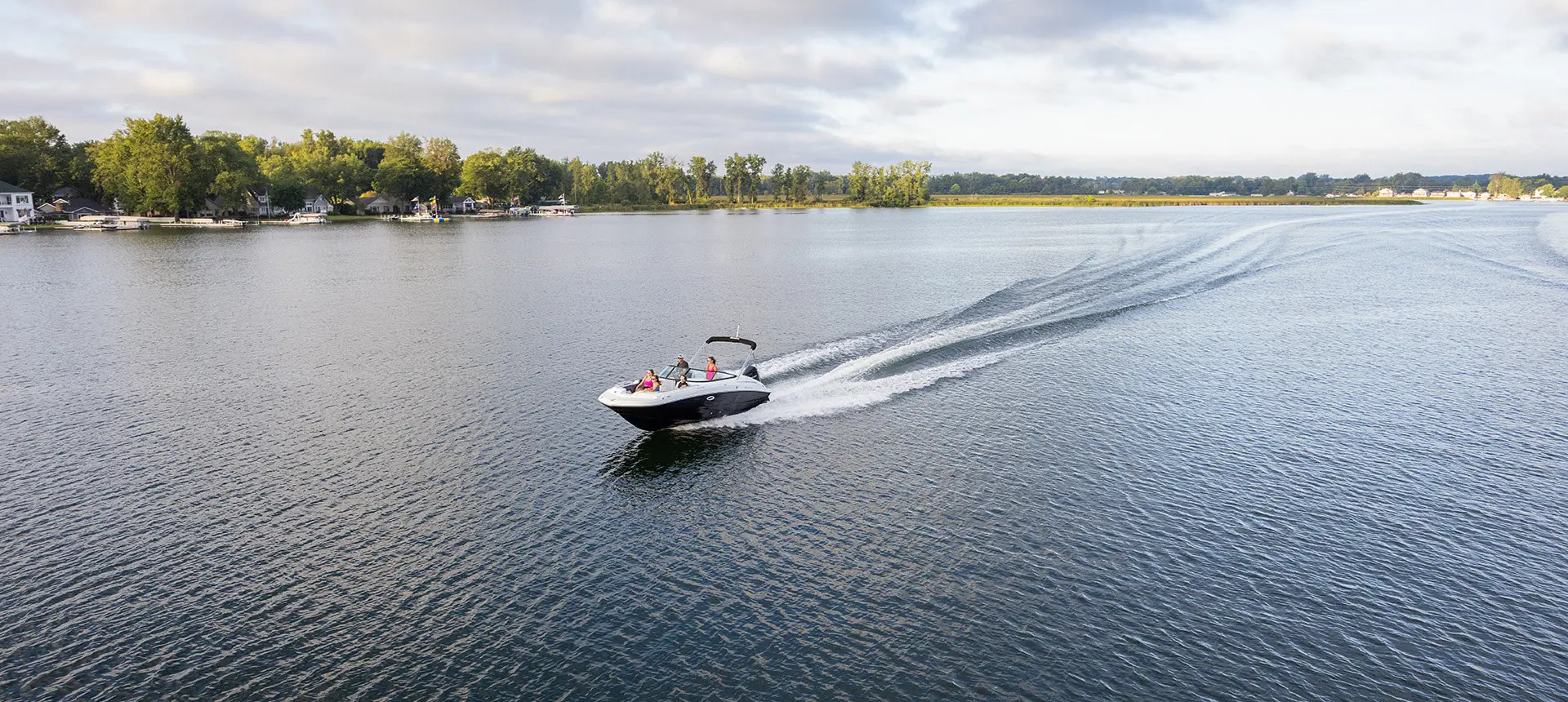 long distant aerial view of a hurricane sundeck 2400 ob deck boat on a lake