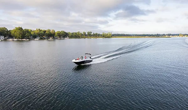 long distant aerial view of a hurricane sundeck 2400 ob deck boat on a lake