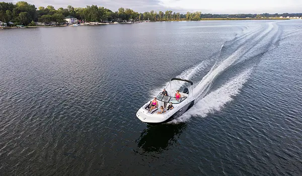 aerial view of a hurricane sundeck 2400 ob deck boat speeding across a lake
