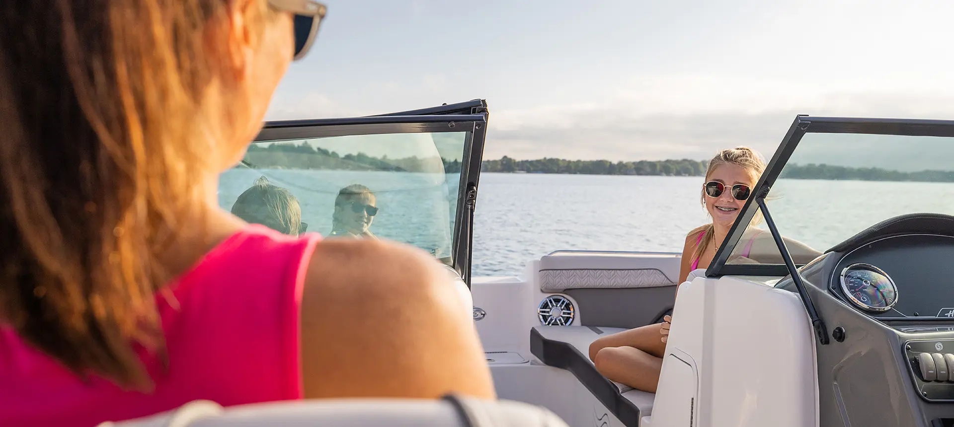 girl smiling at her mom on a hurricane sundeck 2400 ob deck boat